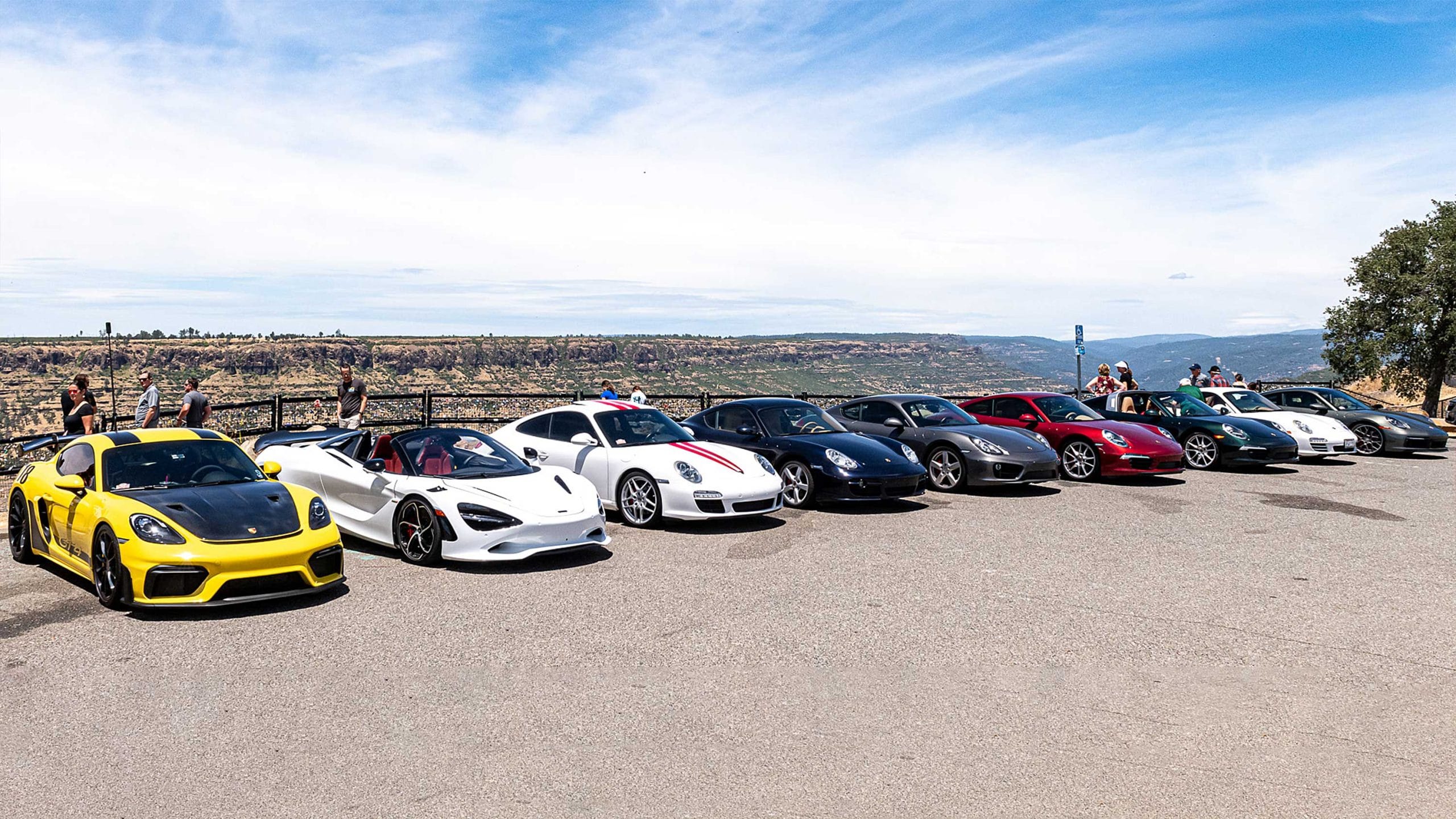 Photo of a row of Porsches with a canyon in the background